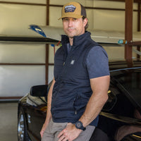 Man wearing Flight Outfitters Insulated Airfoil Vest inside airplane hangar