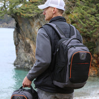 Man wearing Flight Outfitters Aviator Backpack, looking out over lake