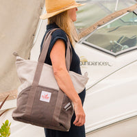 Woman with Grey Flight Outfitters Tote Bag in front of airplane