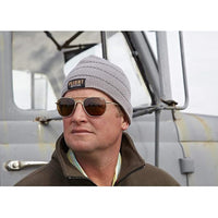 Flight Outfitters owner Mark Glassmeyer wearing grey with black stripe beanie in front of truck