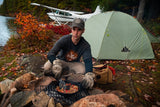 A man cooking while wearing the Flight Outfitters Retro Logo Long Sleeve T-Shirt, showcasing its casual and functional design.