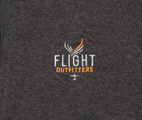 Close-up view of the Flight Outfitters logo on the Women's Fairbanks Fleece in Heather Obsidian, emphasizing branding details.