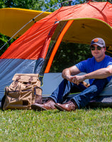 Flight Outfitters Bush Pilot Rucksack set up in front of a tent for an outdoor adventure.