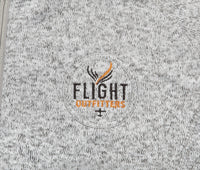 Close-up view of the Flight Outfitters logo on the Women's Fairbanks Fleece in Heather Stone, emphasizing its quality and craftsmanship.