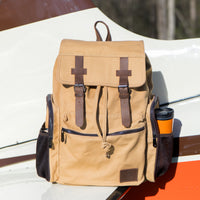 Flight Outfitters Bush Pilot Rucksack resting on the wing of an aircraft, highlighting its aviation connection.