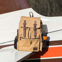 Flight Outfitters Bush Pilot Rucksack resting on the wing of an aircraft, highlighting its aviation connection.